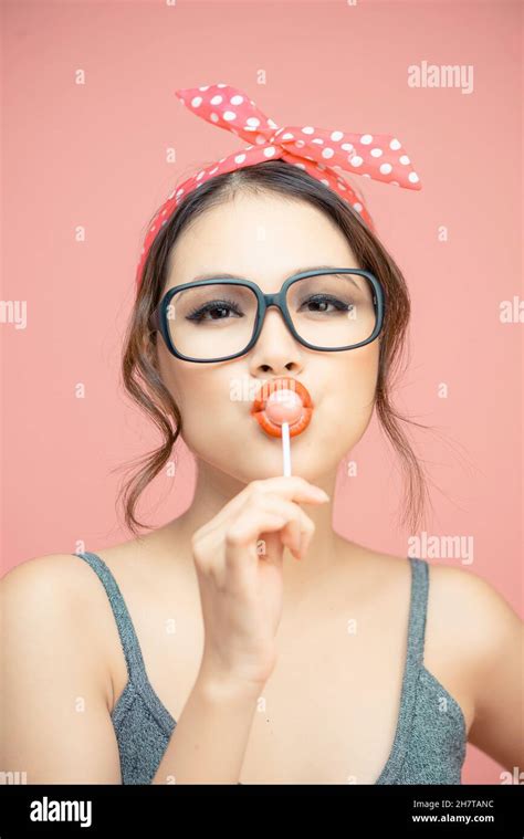 Woman Sucking Lollipop In Lips On Pink Background Isolated Stock Photo Alamy
