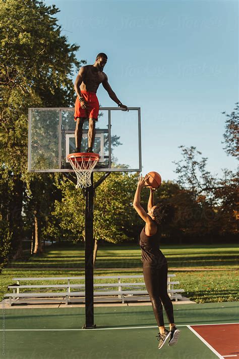 An Attractive African American Couple Playing Basketball On A Sunny