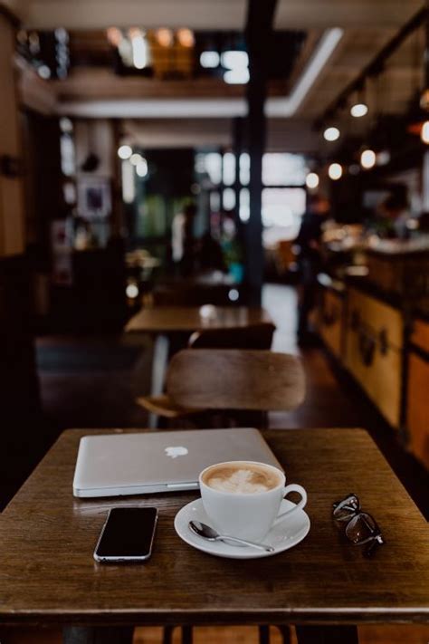 Cup Of Coffee And Macbook Laptop Iphone Mobile Phone On Table In Cafe