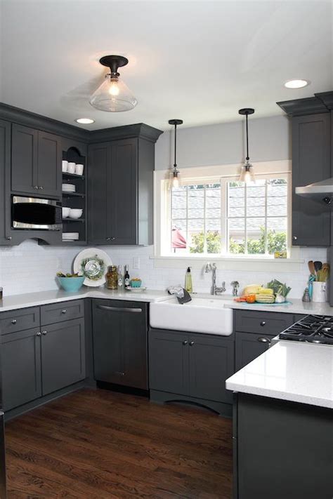 Well designed gray and black kitchen boasts black cabinets contrasted with a white quartz countertop fixed against gray brick wall tiles and beneath charcoal gray french kitchen cabinets are complemented with brass hardware and a marble countertop holding a sink with an antique brass. Beautiful U-shaped kitchen with dark gray shaker cabinetry which pairs with nick… | Grey kitchen ...