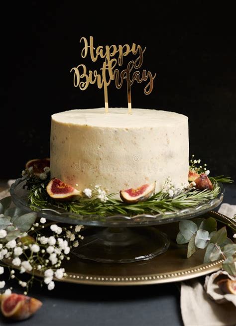 Vertical Shot Of A White Happy Birthday Dream Cake With Green Leaves At The Bottom Stock Photo