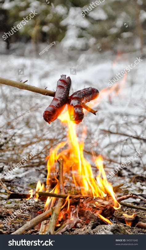 Sausages On The Stick Grilled In The Fire Winter Camp Stock Photo