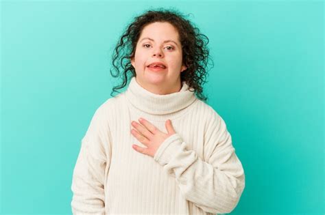 premium photo woman with down syndrome isolated laughs out loudly keeping hand on chest