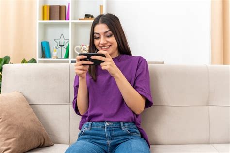 Free Photo Young Girl In Casual Clothes Playing Games Using Smartphone Happy And Excited