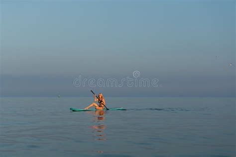 Girl With A Paddle Young Blonde Woman On A Sup Board In The Sea At