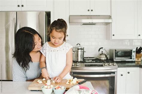 Mom And Daughter Making A Snack Together In Kitchen Del Colaborador De Stocksy Kristin Rogers