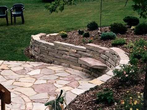 Large Stone Retaining Wall With Patio And Sitting Stones Oasis