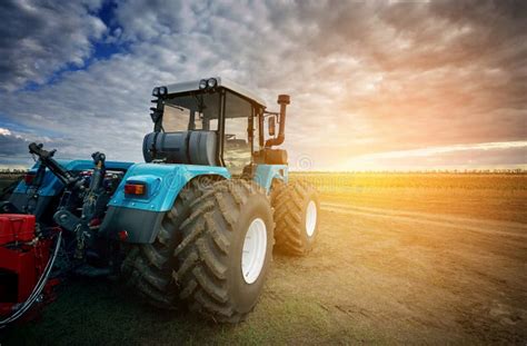 Tractor Working In The Field In The Background Of The Sunset Stock