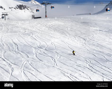 Skier Downhill On Snowy Ski Slope With Trace From Skis And Snowboards