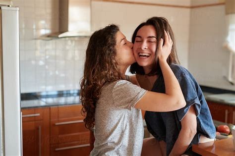 Happy Kissing Girls In Kitchen By Stocksy Contributor Guille