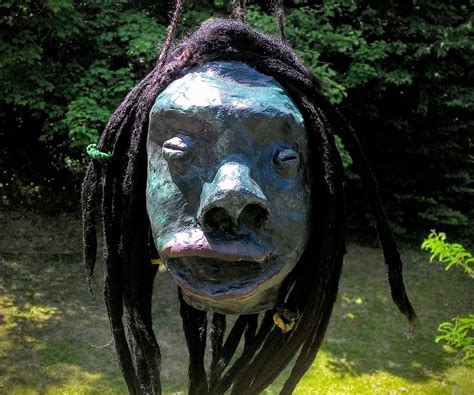 A Sculpture Of A Face With Dreadlocks Hanging From Its Sides In Front