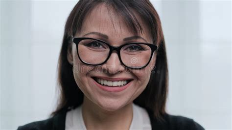 close up face portrait of beautiful mature woman with glasses smiling with teeth stock footage