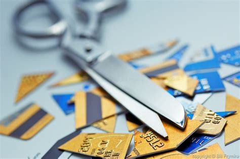 Prevent cutting up your credit card by forcing yourself to be more mindful with your money. scissors on top of cut up credit cards