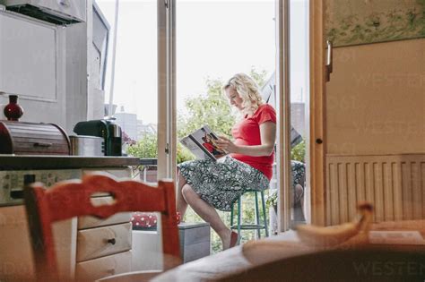Schwangere Frau Sitzt Auf Dem Balkon Und Betrachtet Fotobuch