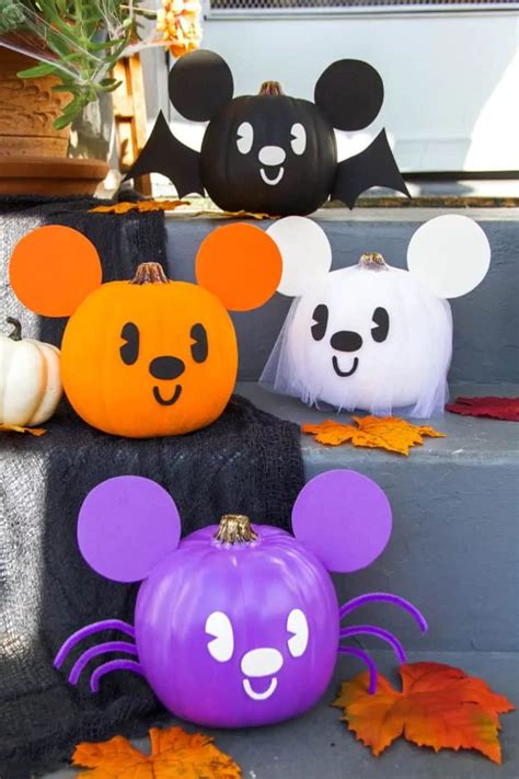 Three Pumpkins Decorated With Mickey Mouse Faces And Ghost Heads On The