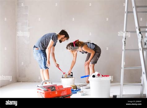 Young Couple Painting Walls In Their New House Stock Photo Alamy