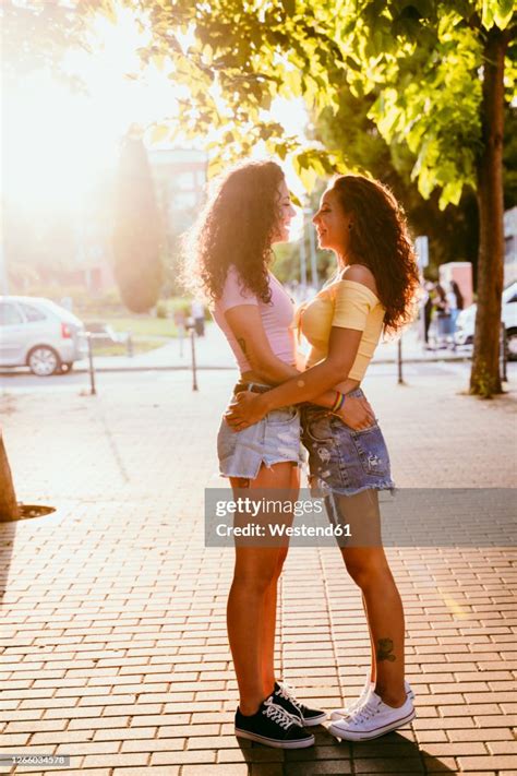 Lesbians Looking At Each Other While Standing On Footpath In City