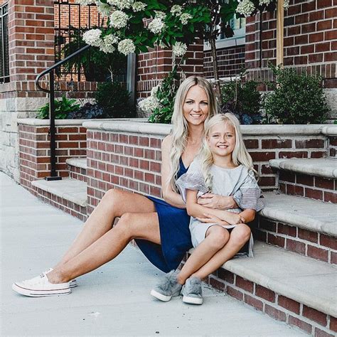 A Mother And Her Daughter Sitting On The Steps In Front Of A Brick