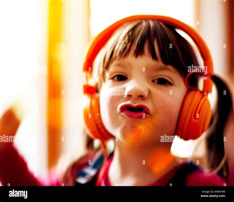 4 6 Years Old Child Dancing With Orange Headphones Hi Res Stock