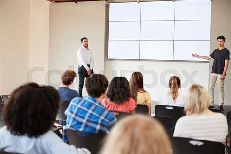 Male Student Giving Presentation To High School Class In Front Of