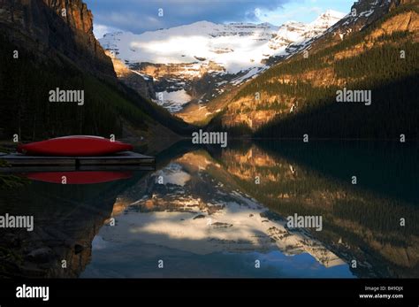 Red Canoes And Victoria Glacier Reflecting In Lake Louise At Sunrise