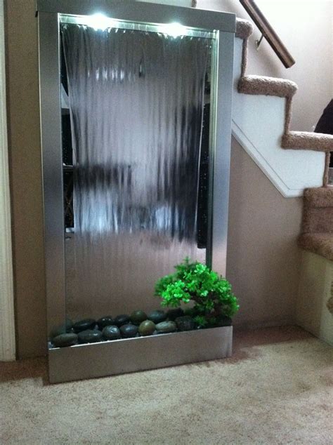 An Indoor Shower With Plants And Rocks In The Bottom Right Hand Corner