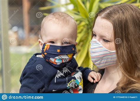 Portrait Of Baby And Mother Together With Reusable Protective Face Mask