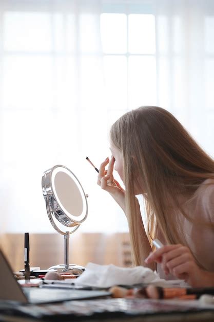 Free Photo Young Woman Putting On Makeup