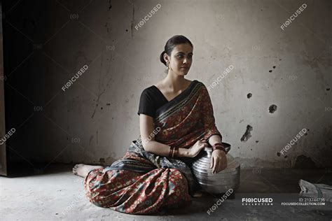 Indian Woman Sitting On Floor In Dimly Lit Room — Looking Away Asia