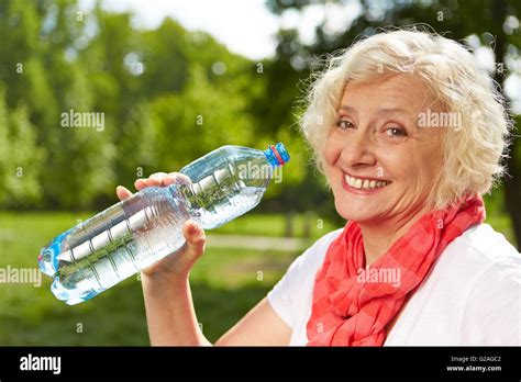 Smiling Senior Woman Drinking Fresh Water In Summer Stock Photo Alamy