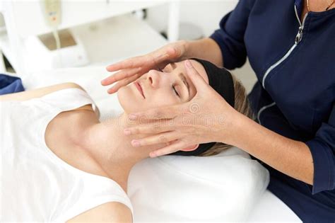 Aeathetician Performing Professional Facial Massage On Woman Face At Spa Clinic Stock Image