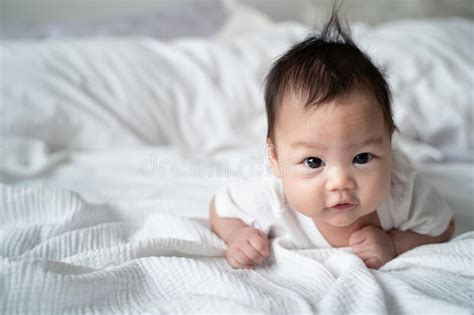 Happy Asian Baby Infant Learning To Crawl On White Soft Bed 3 Months