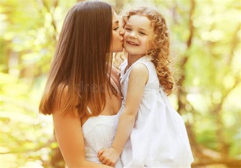 Madre Besando A Su Hija Pequeña En El Parque De Verano Imagen De