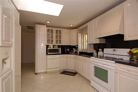 As this kitchen shows, going all black with the cabinets can still result in a surprisingly bright kitchen. Can you post your pics of kitchens with white appliances?