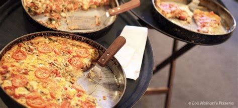 Three Pans Filled With Pizza Sitting On Top Of A Metal Table Next To