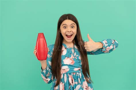 Surprised Child With Long Hair Hold Shampoo Bottle Show Thumb Up