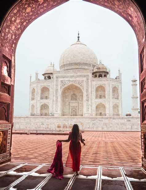 A Woman In A Red Dress Is Walking Towards The Tajwa Mosque India