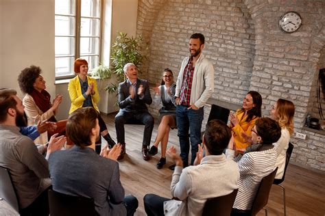discussion business group- coworkers applauding man in ...