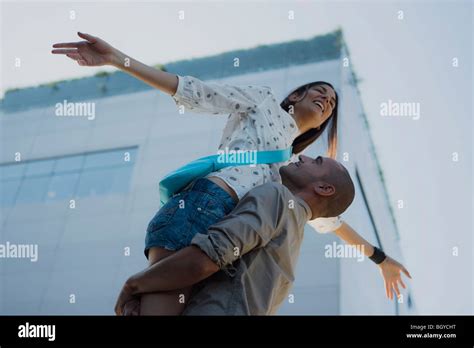 Man Lifting Woman In Air Womans Arms Outstretched Stock Photo Alamy