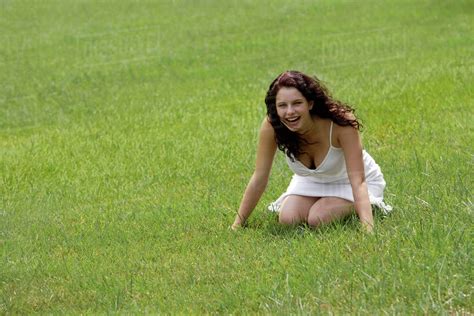 Woman Laughing Sitting On Feet On Grass Stock Photo Dissolve