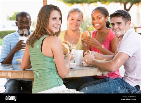 Group Of Teenagers Sitting Outdoors Eating Fast Food Stock Photo Alamy