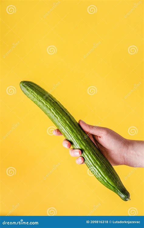 Female Hand Holding Cucumber On Yellow Background Woman Hold Green