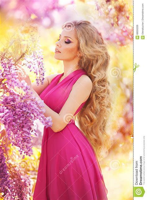Fashion Portrait Of Young Beautiful Girl Posing Against Lilac Bushes In