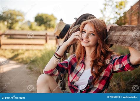 Cheerful Cute Redhead Cowgirl Resting At The Ranch Fence Stock Image