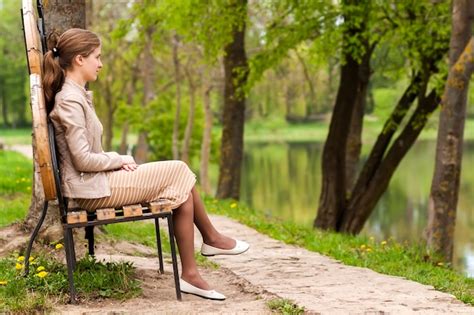 Premium Photo Beautiful Young Woman Sitting On Bench In Park Looking Ahead