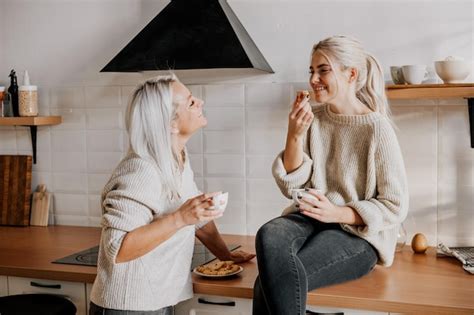 Joven Madre E Hija Adolescente Riendo Y Hablando En La Cocina Foto