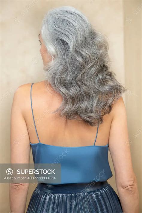 Medium Close Up Of A Middle Aged Woman With Grey Hair Turned Away From Camera Superstock