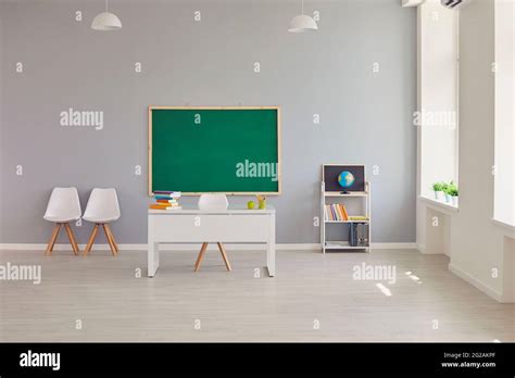 Interior Of Empty School Classroom With Teachers Desk And Clean Green
