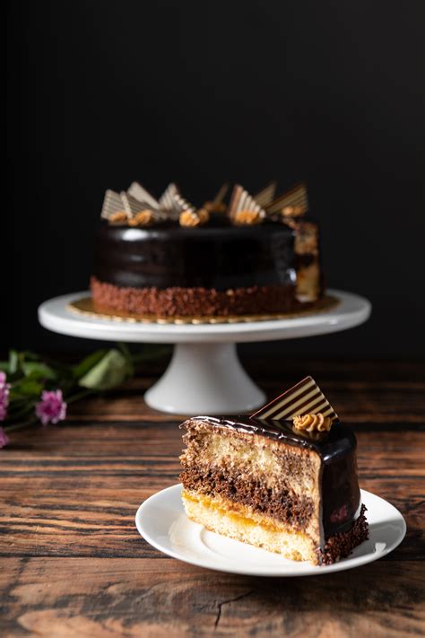Garnished with chocolate ganache and berries. Kahlua Cake and slice - Nugget Markets Image