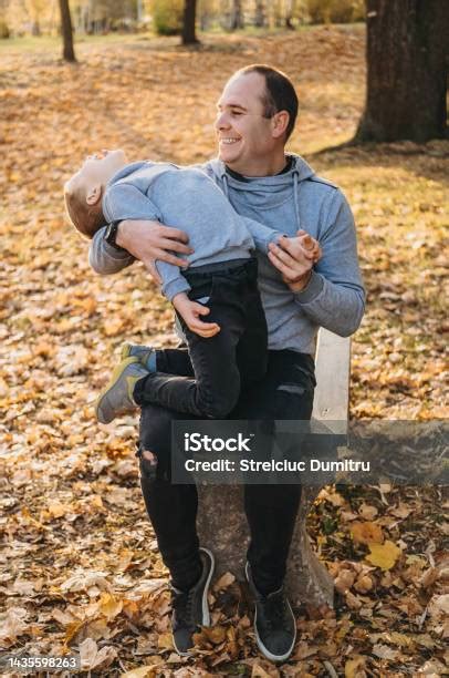 photo libre de droit de père heureux assis sur le banc en bois dans le